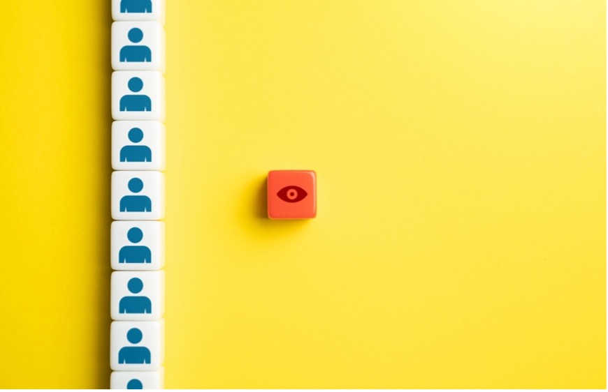 A red cube with a red eye and white blocks with people on them
