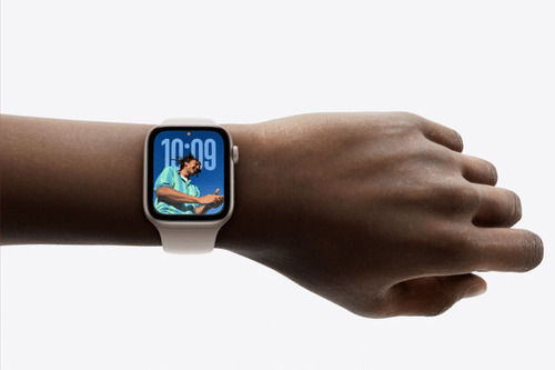 Apple watch showing the time placed on someone's wrist with a white background